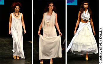 Three models showcase designs from A.M.K. during at Calgary Fashion Week. The line features clothes in different volumes and textures of white fabric. Models walked the runway with matted, messy hair and charcoal smudged eye makeup.