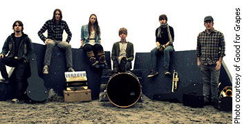 The six teenage members of Good for Grapes sitting together on a beach