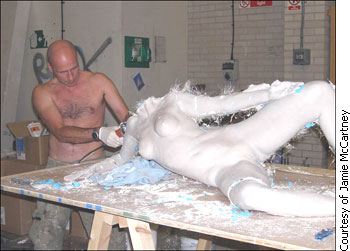 Jamie McCartney working on a plaster figure of a woman's body.