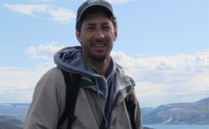 Sam Iverson stands in front of an icy backdrop in the Canadian Arctic