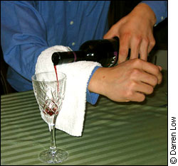 man pouring wine into glass